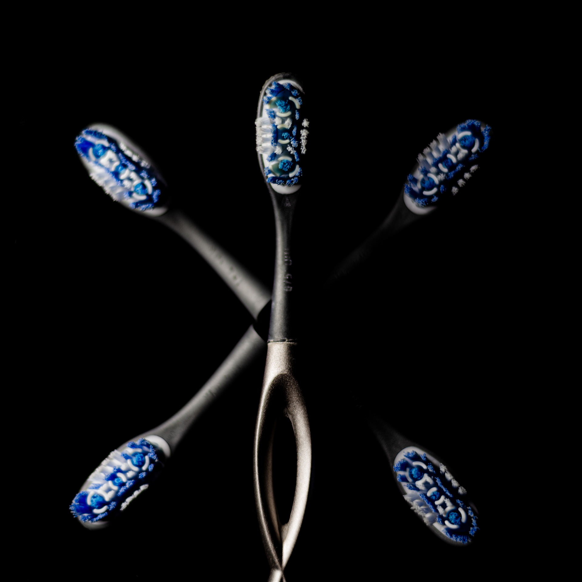A close up of a toothbrush with five heads in a flower pattern.