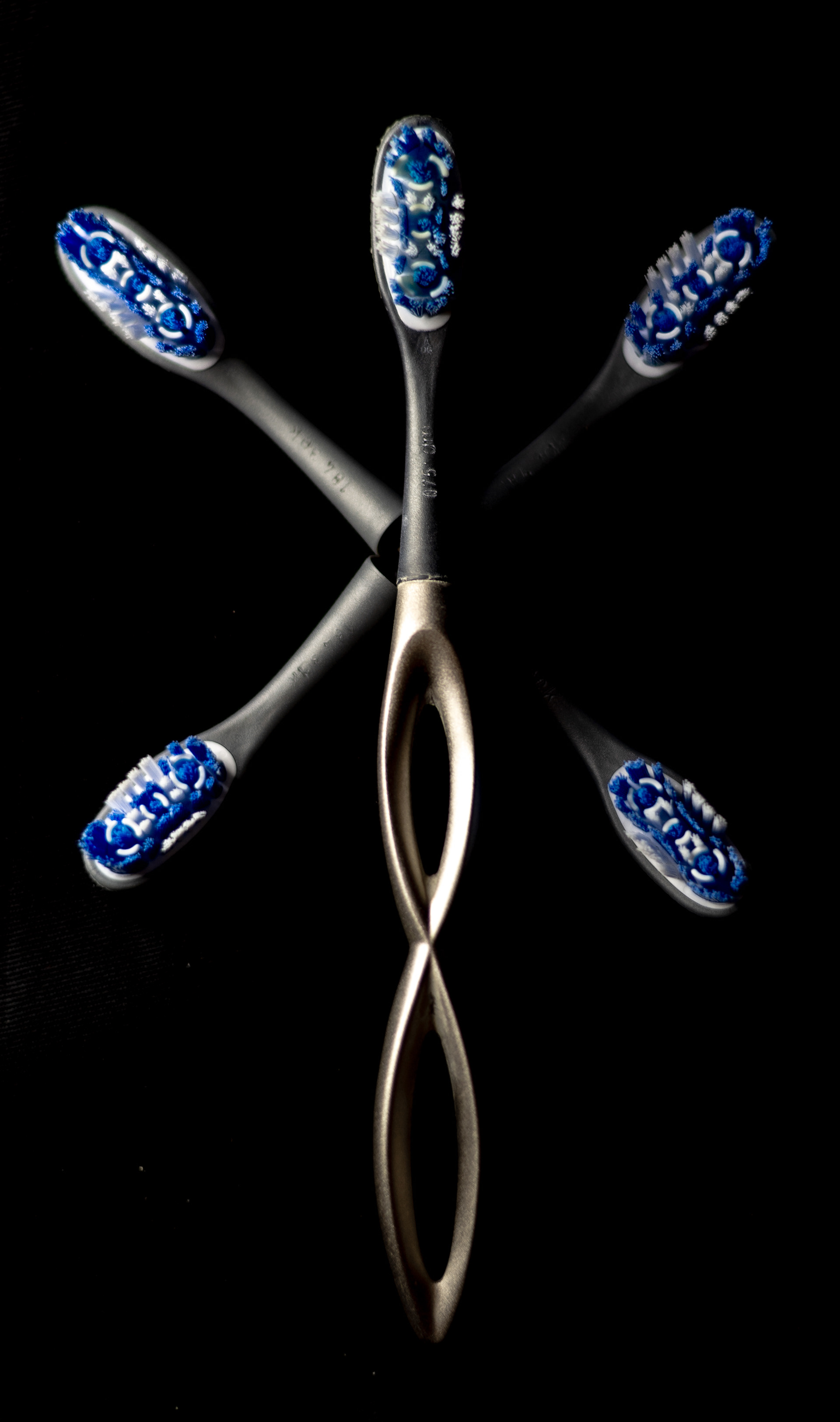 A helical toothbrush with five brush heads in a flower pattern.