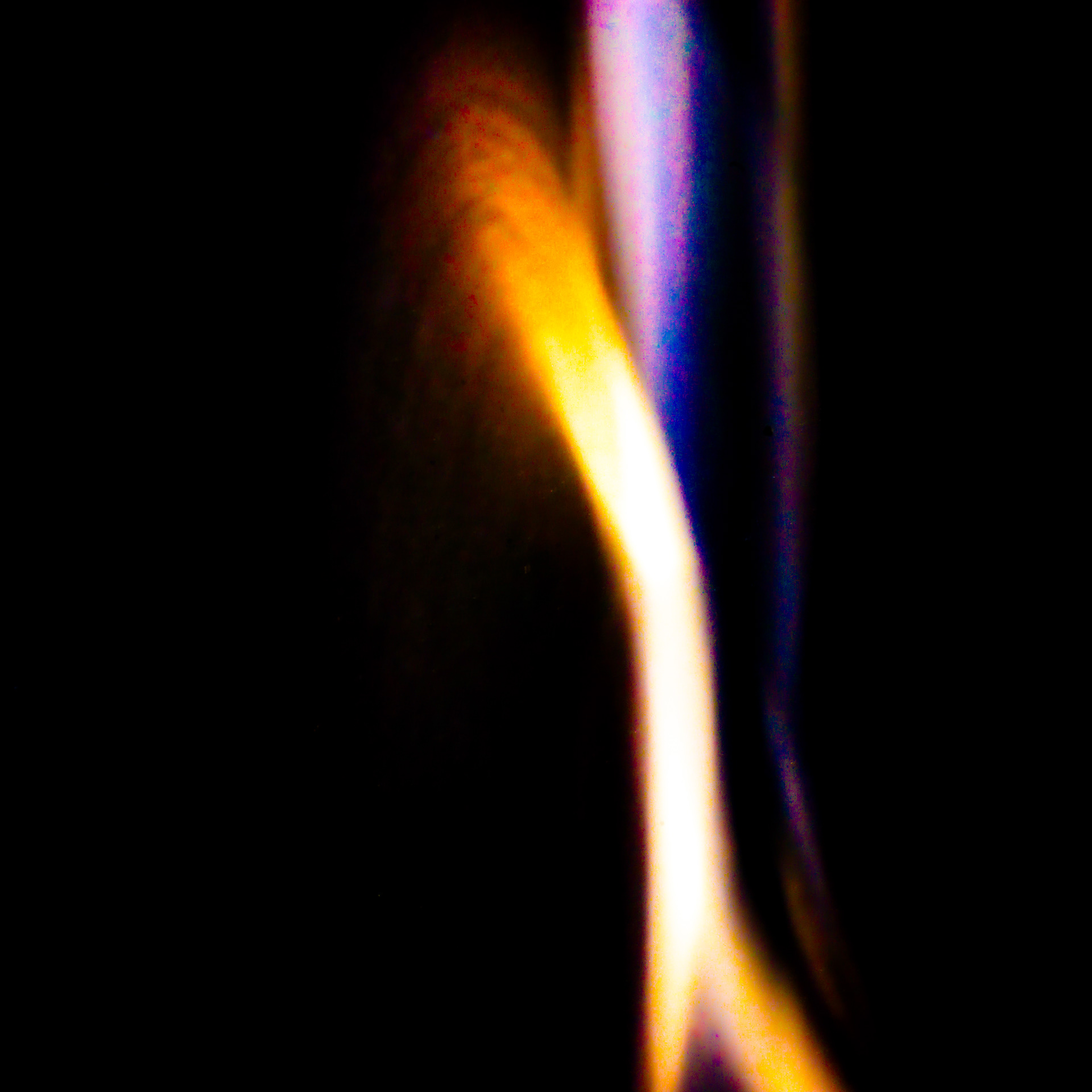 A blurry photo of a metal toothbrush falling appears like a streak of blue and red flame.